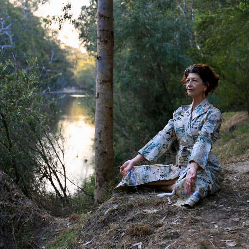 Sue Everett is meditating by a river